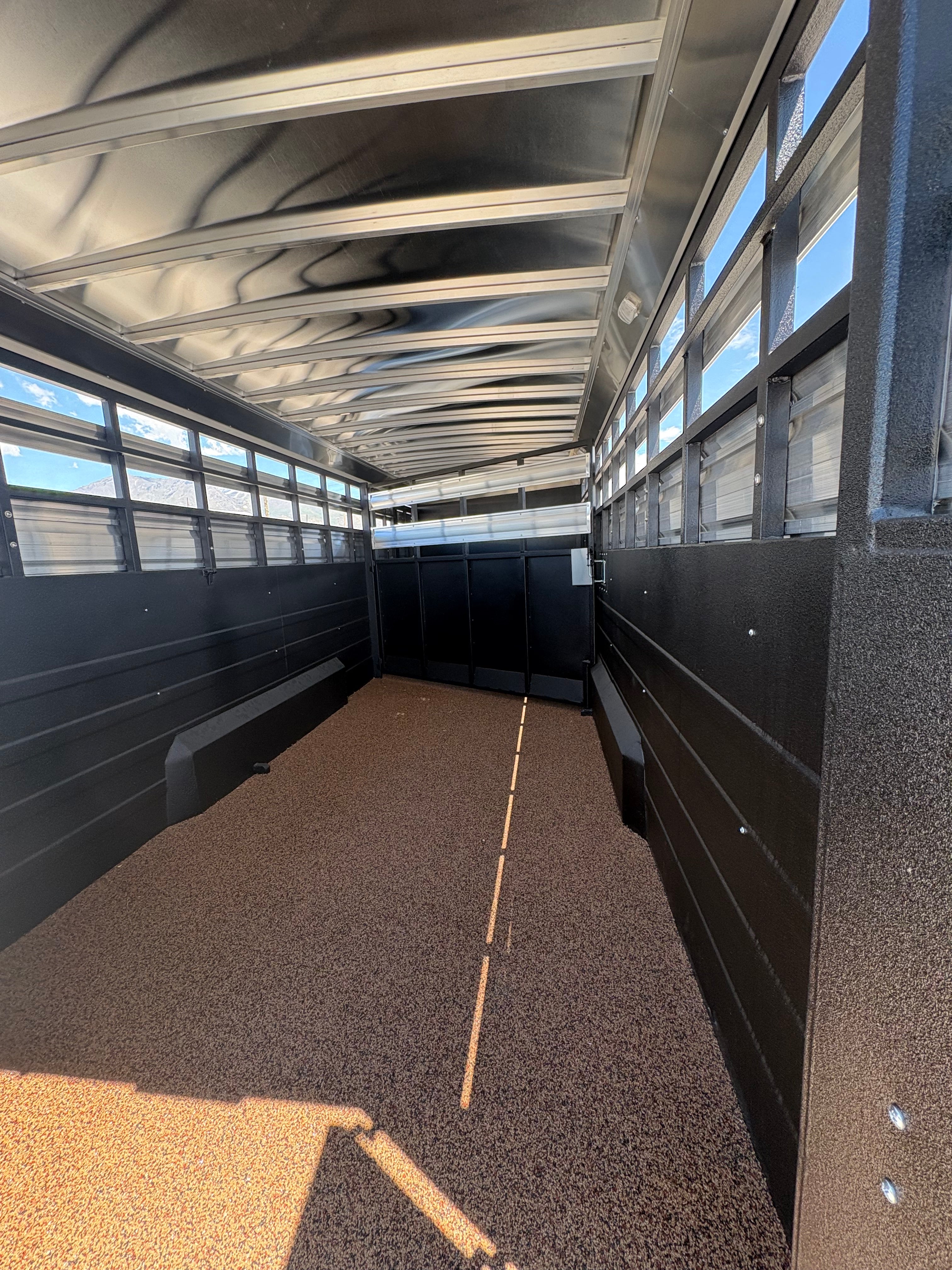 Logan Coach 26 stock combo trailer interior with livestock area, rubber floor, side vents and divider gate for horse and cattle transport.