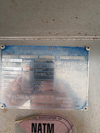 close up of Featherlite trailer manufacturer plate showing model number, VIN, size specifications, weight ratings and production details on aluminum data tag mounted inside trailer.