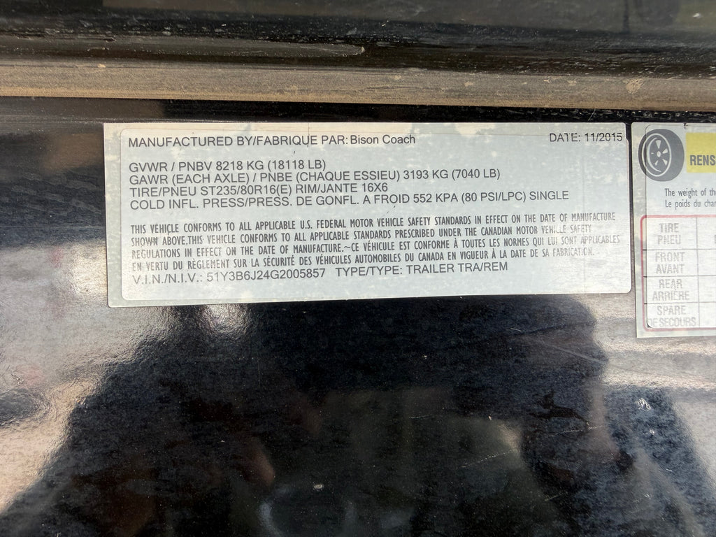 Bison Coach horse trailer VIN and weight specification label showing GVWR, axle rating and tire details on livestock trailer.