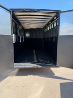 interior horse hauling compartment with black padded walls, rubber floor matting, roof ventilation, side tie points, and open loading space inside Logan Coach Crossfire trailer.