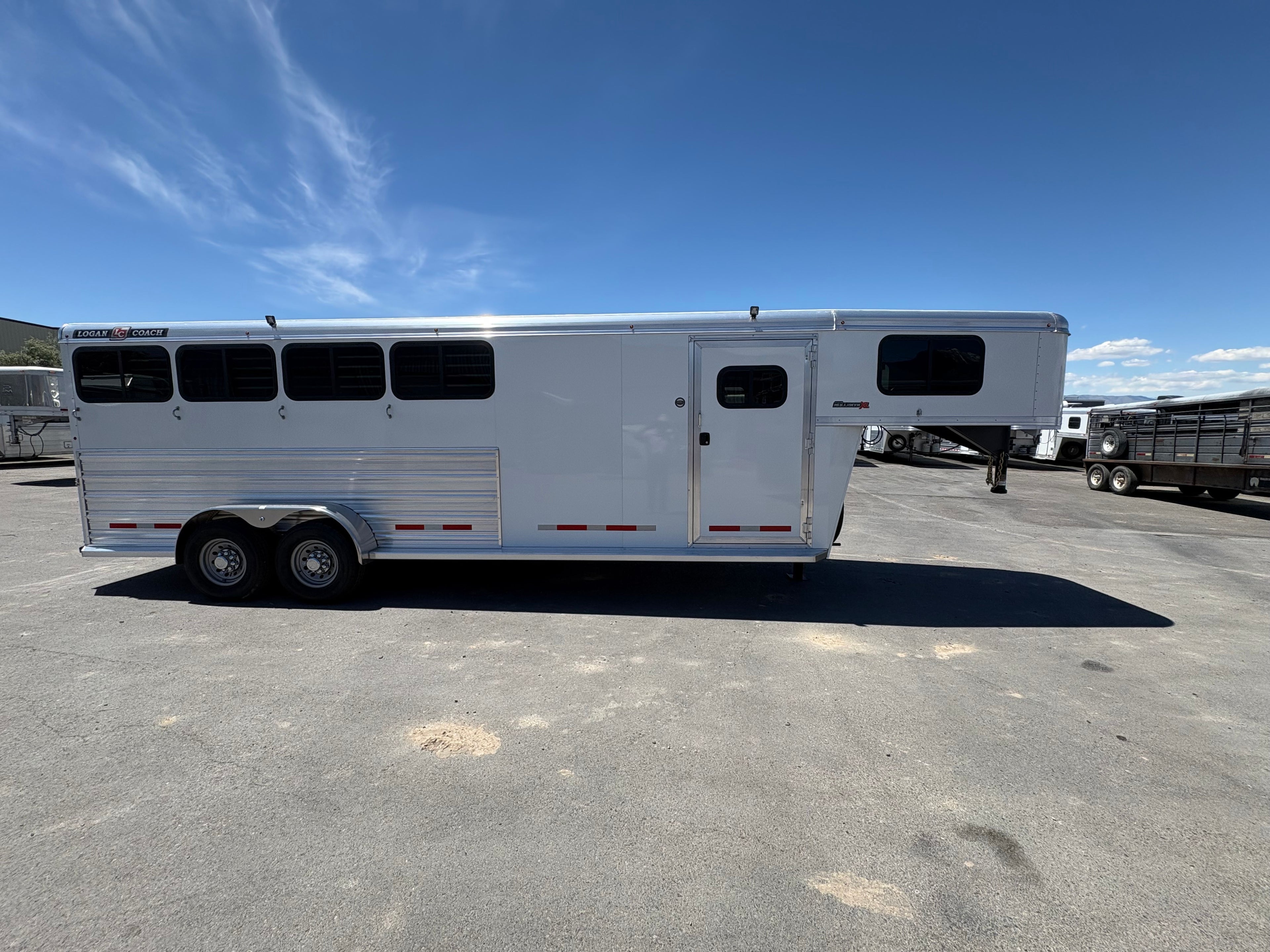 Logan Coach Bullseye XL 4 horse trailer driver side view with tack room door and dual axle wheels
