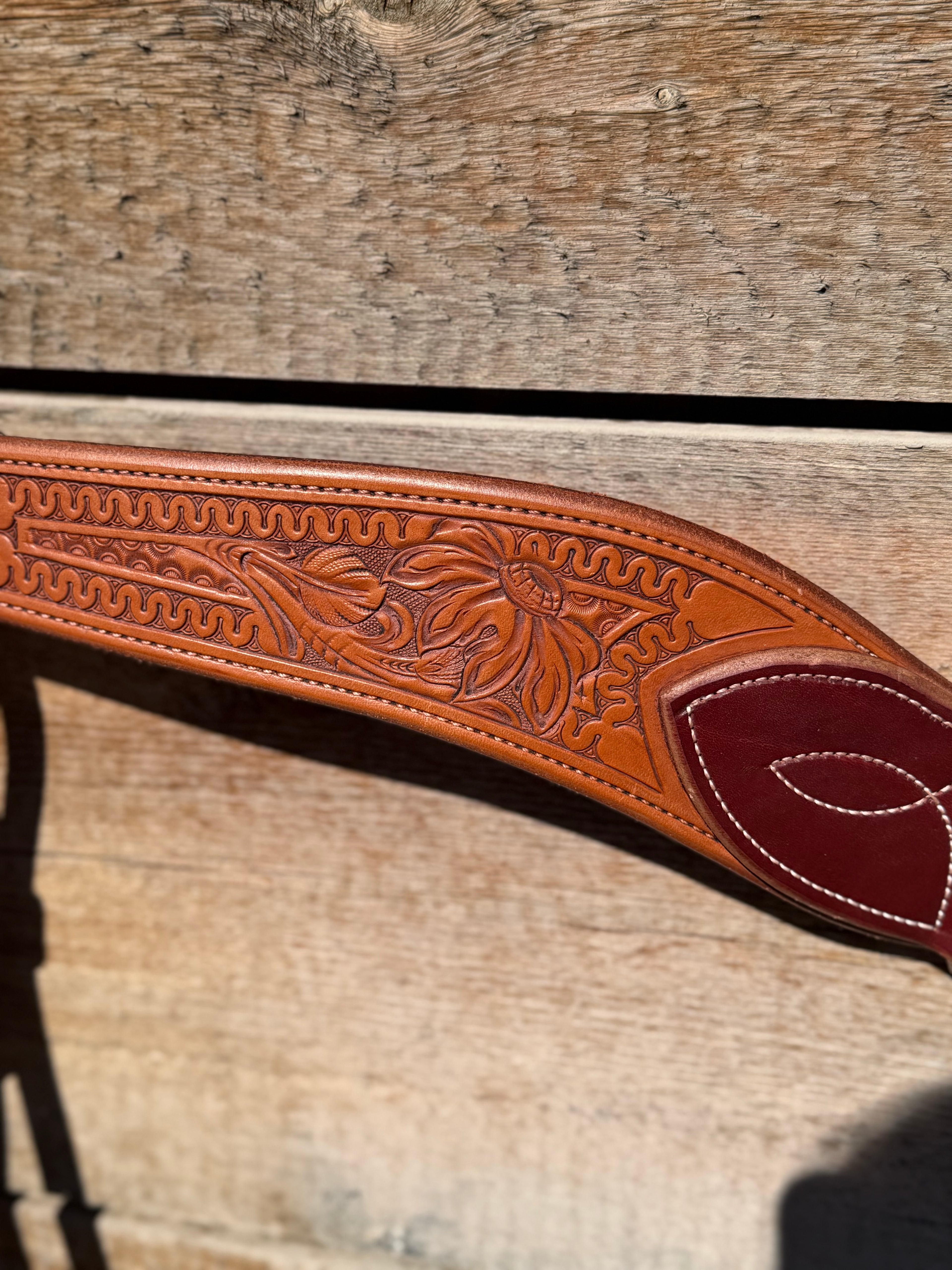 Shane Deater custom leather breast collar close up with floral tooling and stitched two tone leather detail on western horse tack.