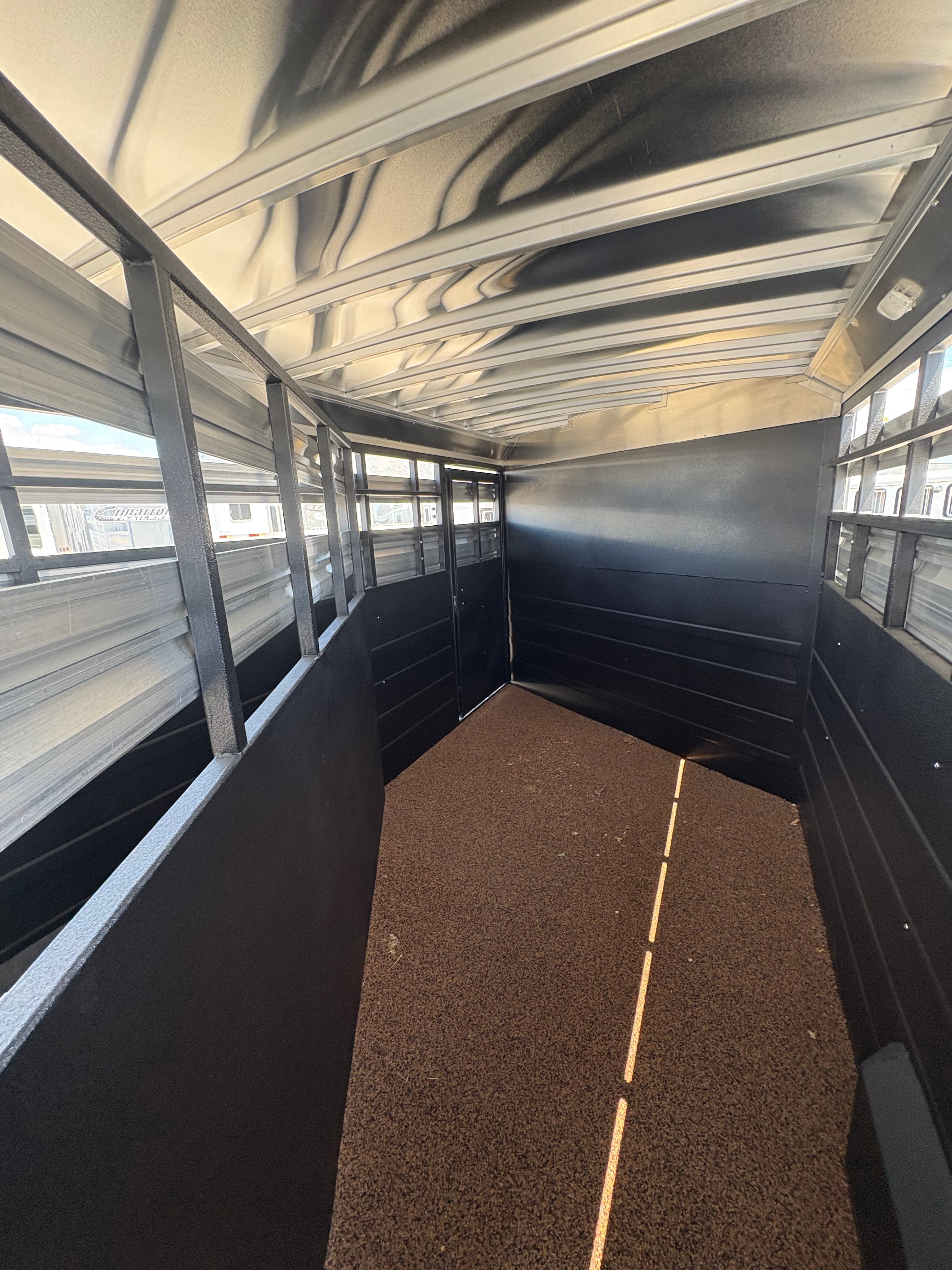 Logan Coach 26 stock combo trailer interior with rubber floor, side vents and rear gate, livestock area for horse and cattle transport.