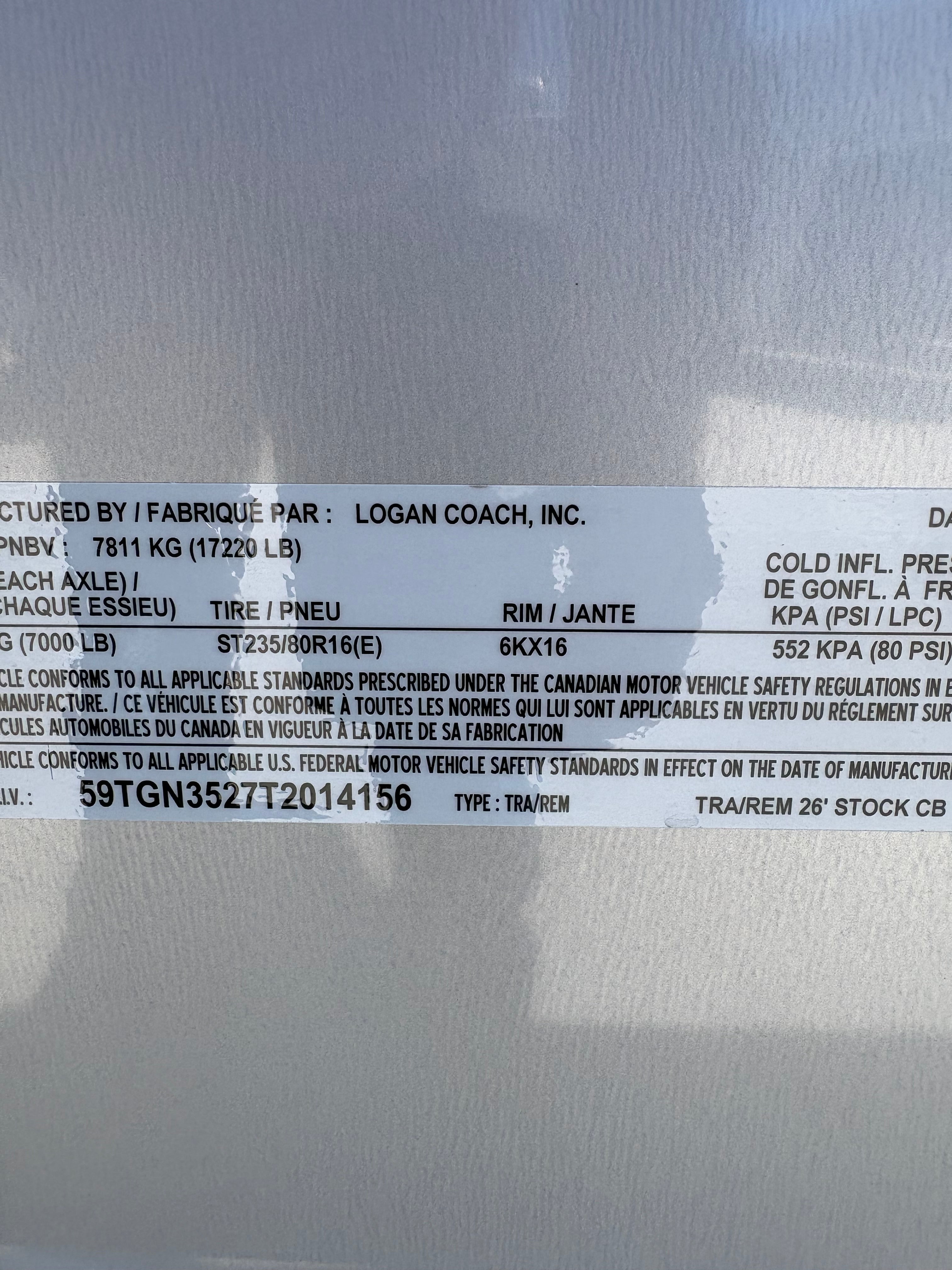 Logan Coach 26 stock combo trailer VIN and specification label showing GVWR, axle rating and tire details on aluminum livestock trailer.
