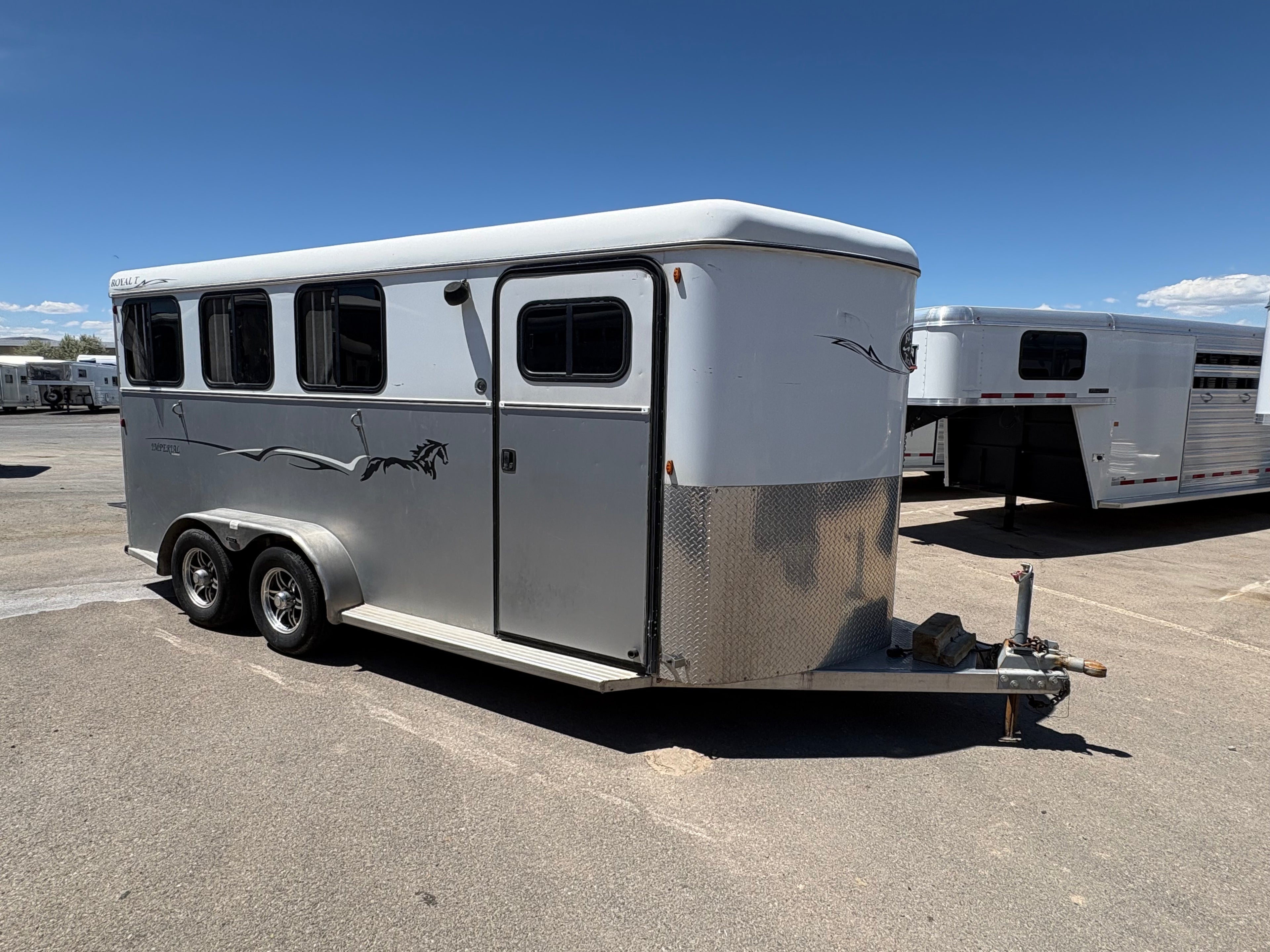 Royal T 3 horse bumper pull trailer front right view showing hitch, tack door, and dual axle wheels.