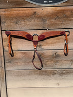 Shane Deater custom leather breast collar with floral tooling, two tone brown leather and stainless hardware on rustic wood background.
