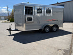side exterior of Logan Coach Crossfire 3 horse trailer with drop down horse windows, gray aluminum siding, tandem wheels, diamond plate trim, and durable bumper pull design parked on paved lot.