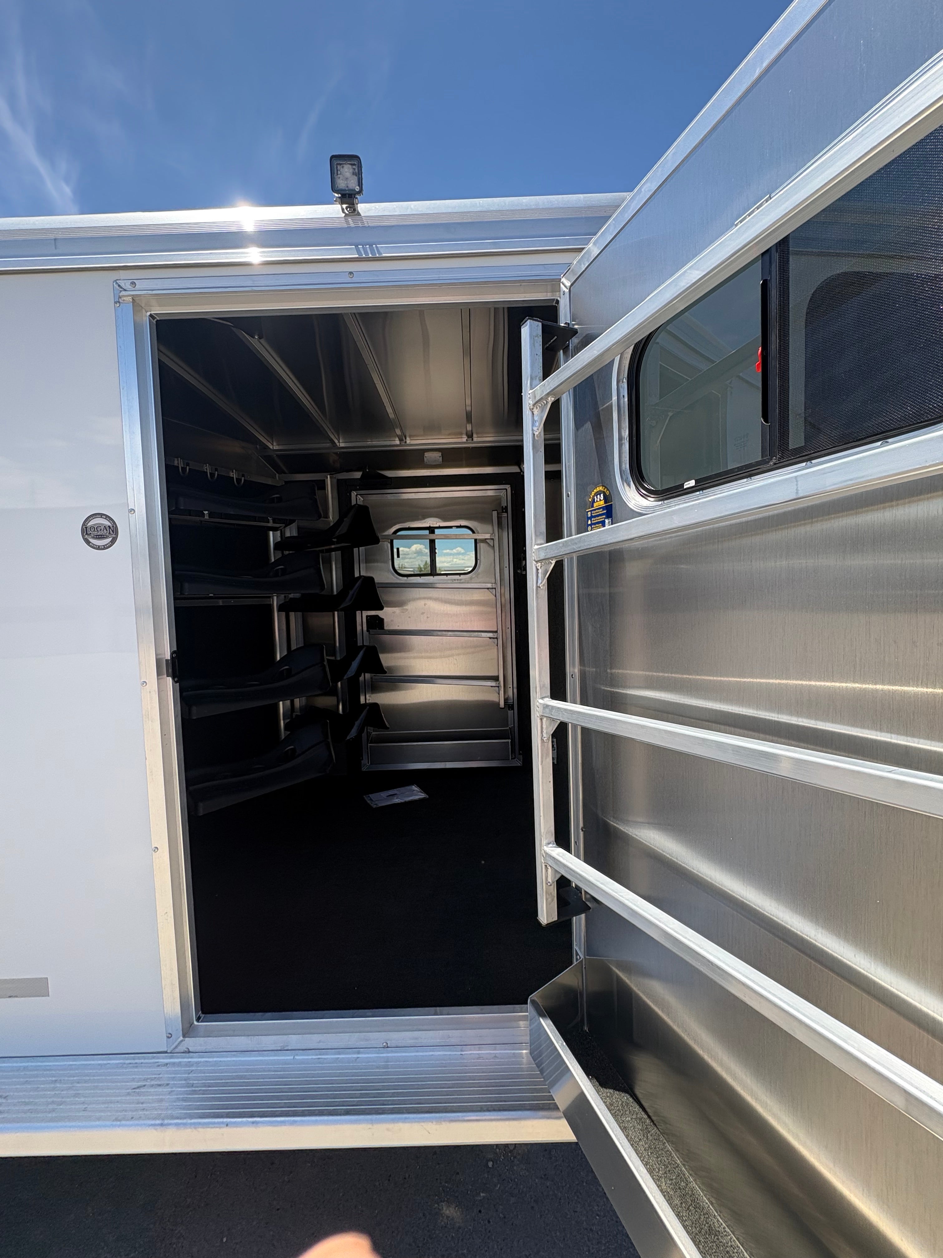 Logan Coach Bullseye XL horse trailer tack room with saddle racks and storage space.