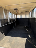 Interior of 2013 Royal T 3 horse trailer showing padded stall divider and aluminum walls.