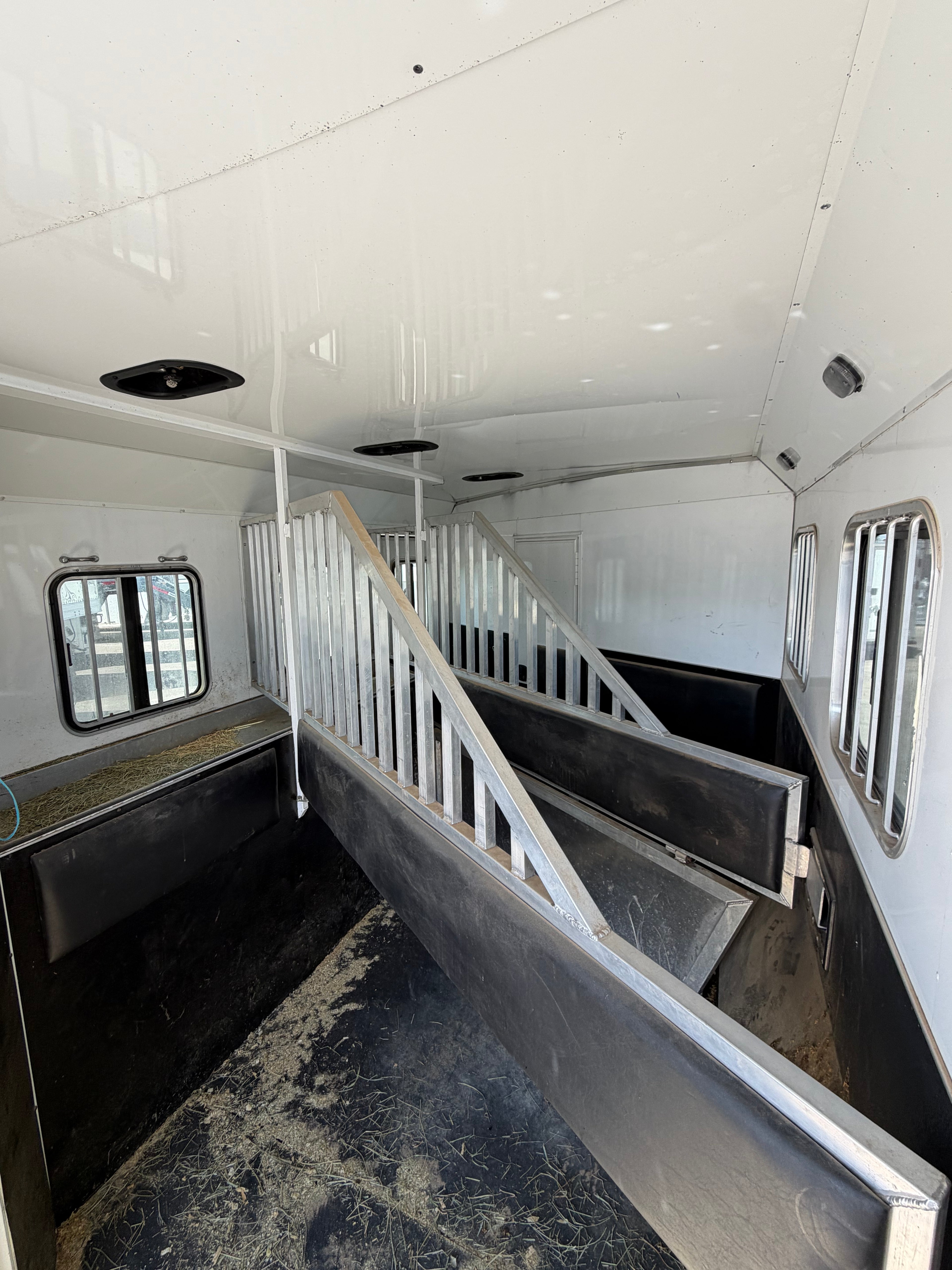 Interior of horse trailer with padded stalls and dividers, livestock compartments for safe horse transport and ranch use.