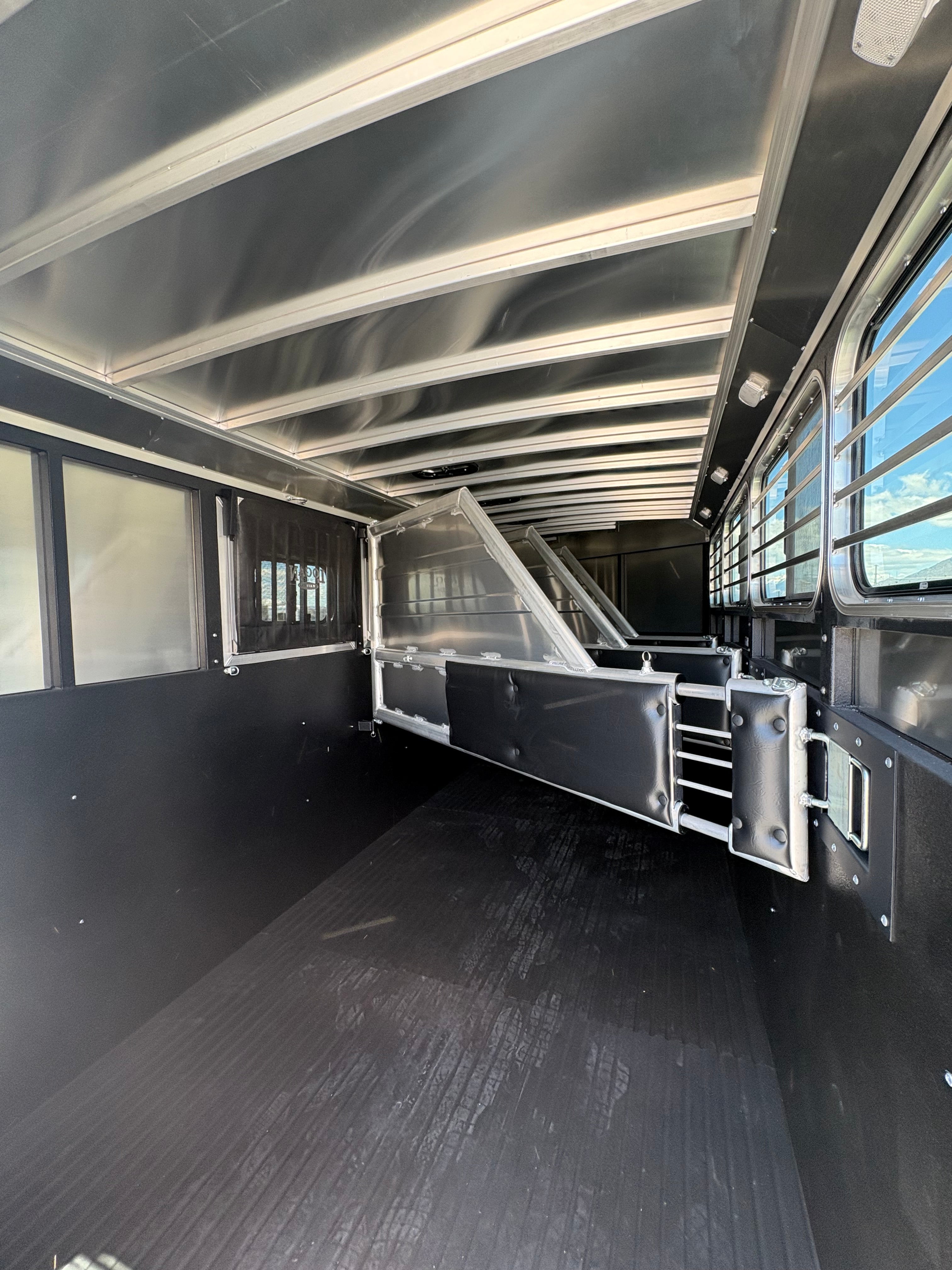 Interior of Logan Coach Bullseye XL 4 horse trailer showing padded dividers and aluminum stall partitions.