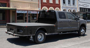 Black pickup truck with an open bed on a city street.